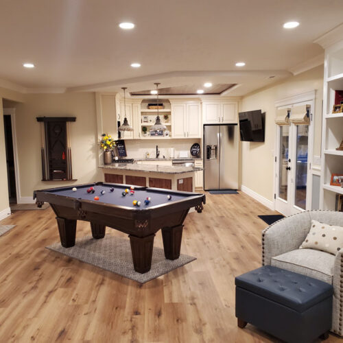 Finished basement remodel with game room in Utah by Pro-Worx Construction with custom flooring and modern design