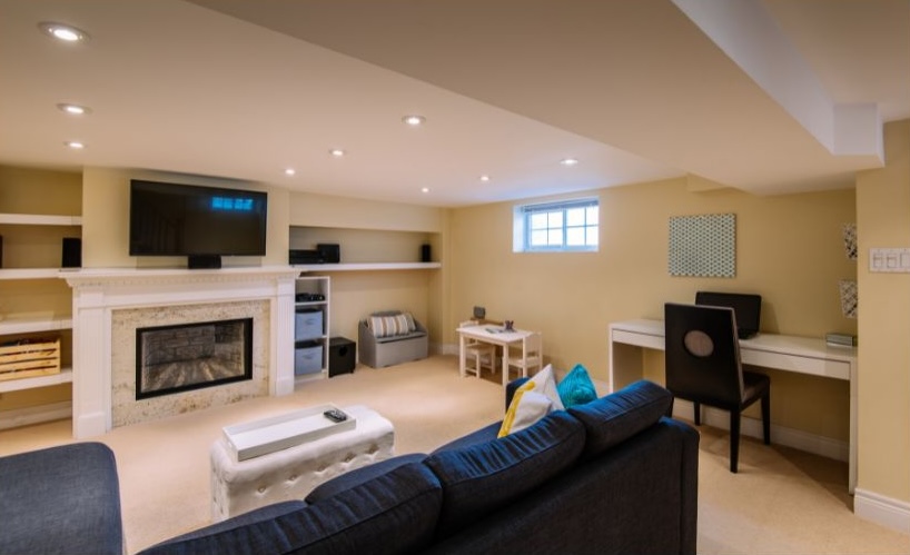 basement home office with couch and tv