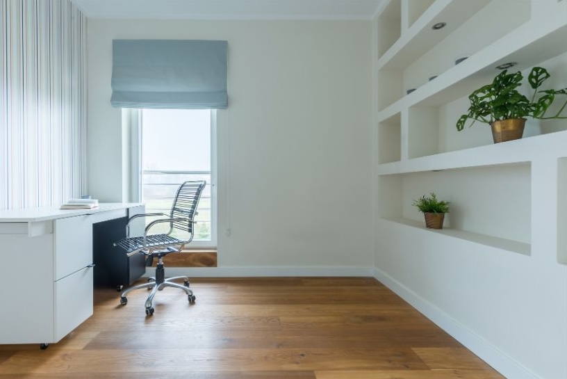 home office with dark timber floors and white shelving