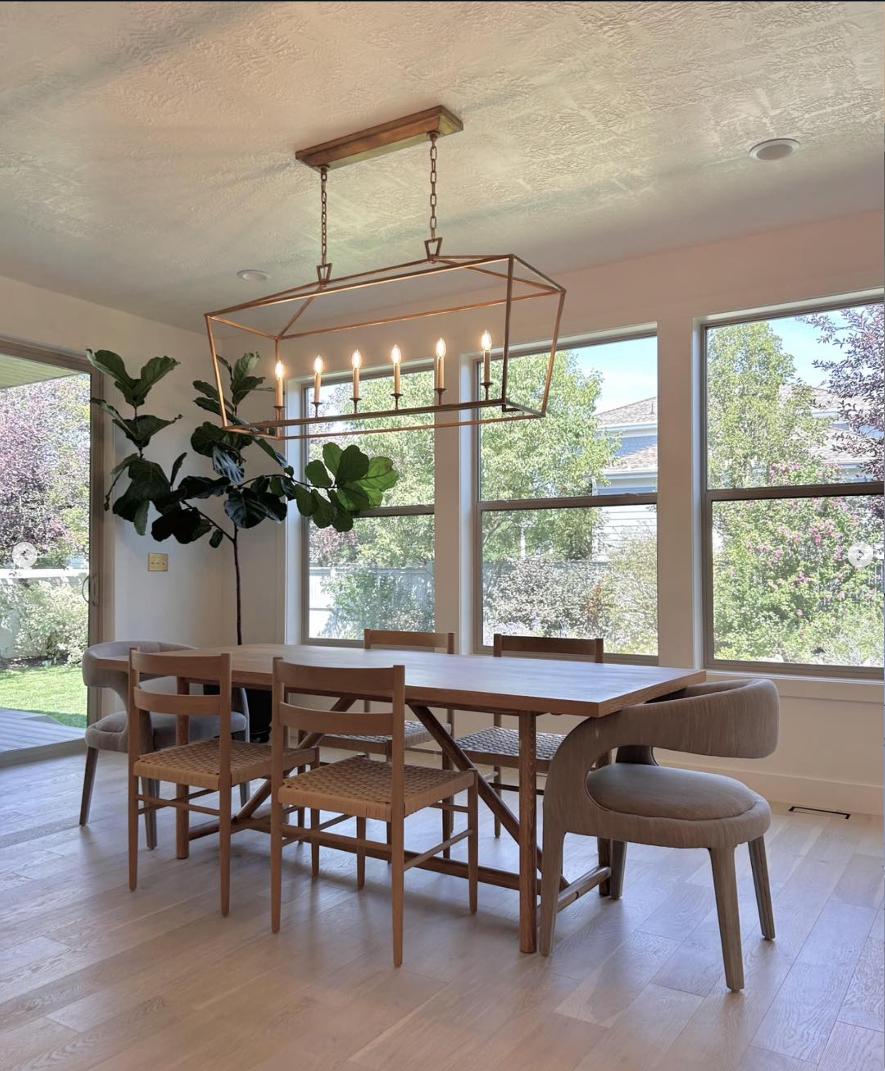 modern-dining-room-chandelier-hardwood-park-city-utah | Pro-Worx Construction Dining room with a copper geometric chandelier over a wooden table and six candles, with large windows behind in lehi by pro worx construction